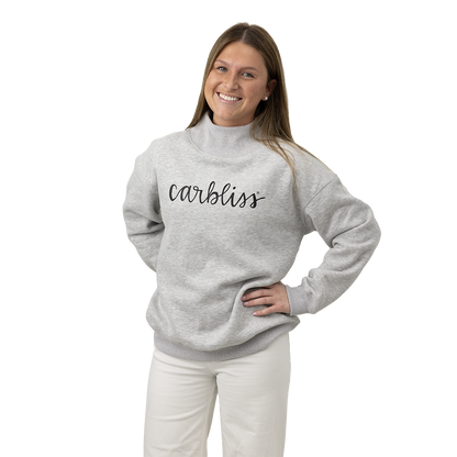 Woman wearing a gray sweatshirt with 'carbliss' text on a white background